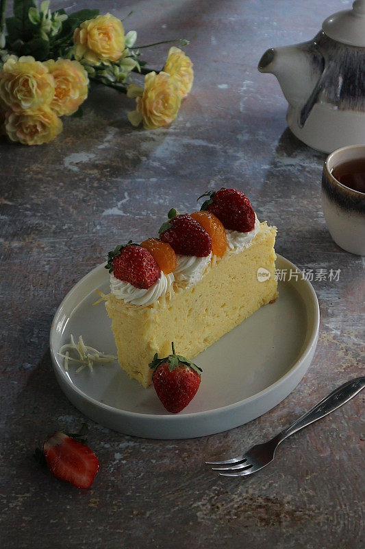 a slice of cheesecake topped with sliced ​​oranges and strawberries